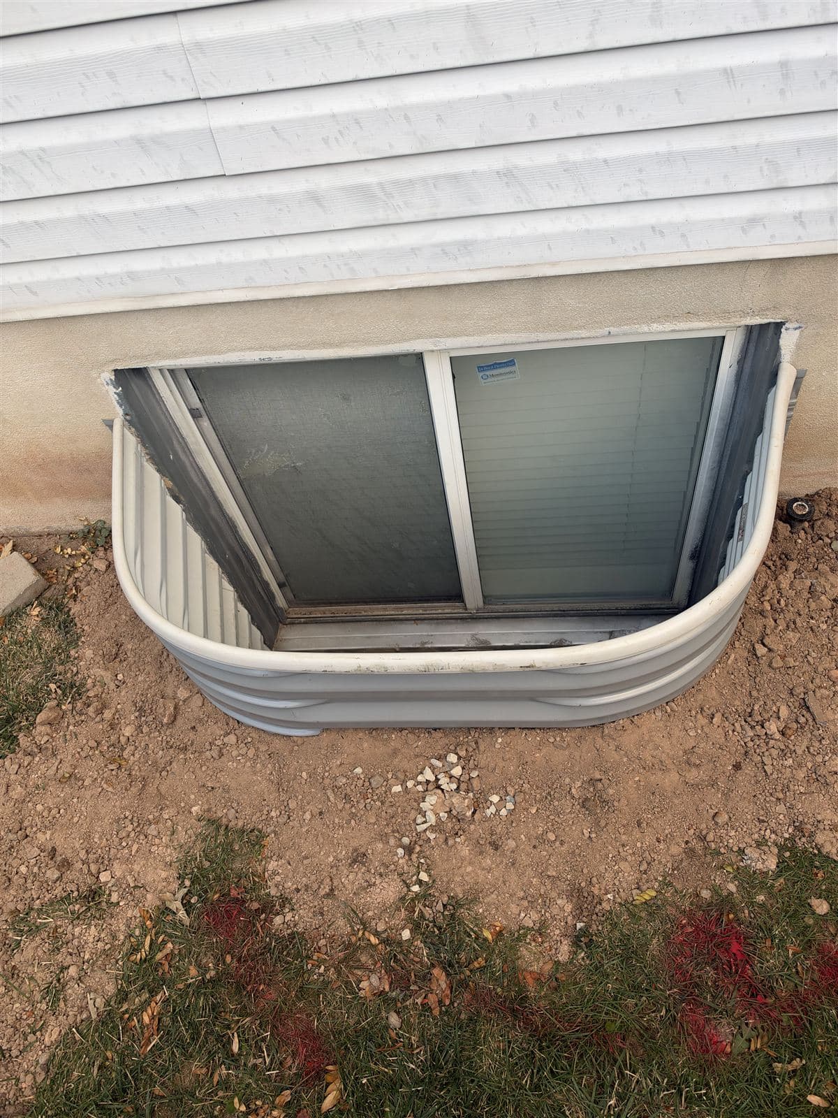 New window well installed flush to the foundation
